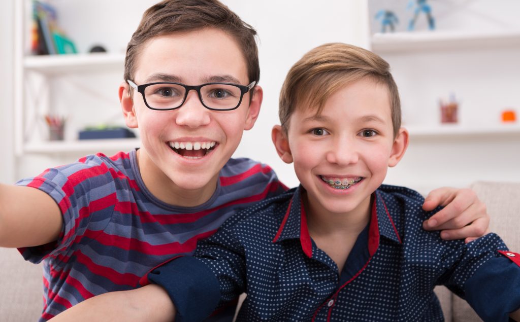 Two young boys smiling and taking a selfie